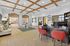 Inviting apartment lobby with warm wood panel ceilings, a modern reception desk, and cozy seating area, highlighting a blend of comfort and style.