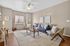 Chic living room with modern furniture, warm lighting, and elegant decor, featuring a blue sofa and accent chairs on a plush rug.
