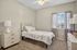 Charming bedroom featuring cozy single bed, elegant lighting, and sunlit window for a serene retreat.