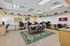 Modern co-working space featuring elegant wooden desks, a central conference table with stylish seating, and abundant natural light.
