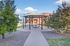 Vibrant apartment complex courtyard featuring a modern gazebo surrounded by lush greenery and colorful building facades.