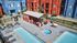 Vibrant apartment complex with a refreshing pool, hot tub, and cozy outdoor seating area. Modern living meets leisure in colorful architecture and serene amenities.