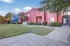 Vibrant apartment complex with striking red and blue facades, lush greenery, and a welcoming modern design.