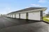 Modern multi-car garage with sleek design, featuring numbered white doors and stone accents for added elegance.