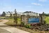 Inviting entrance to Retreat at 42nd Luxury Apartment Homes, featuring modern architecture and lush landscaping against a clear blue sky.