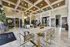 Elegant apartment lobby with high ceilings, modern lighting, and stylish furnishings, including a marble table and chic armchairs.