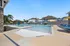 Luxurious outdoor pool area with a zero-entry design, surrounded by stylish blue lounge chairs and sunny yellow umbrellas, perfect for relaxation and leisure.