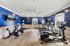 Inviting fitness center with modern cardio equipment, vibrant blue walls, and motivational quotes for an energizing workout.