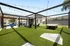Chic outdoor space with modern pergola, lush artificial turf, and stylish seating, perfect for relaxation and entertaining.