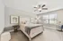 Bright and inviting bedroom with plush bedding, stylish decor, and natural light through large windows.