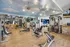 Luxurious fitness center with modern equipment, mirrored walls, and a sky-themed ceiling for an invigorating workout experience.
