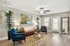 Chic and modern living room with a cozy brown leather sofa, vibrant blue armchairs, stylish artwork, and abundant natural light.