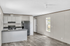 Bright and modern kitchen with sleek gray countertops, stainless steel appliances, and ample natural light.
