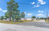 Charming community of mobile homes surrounded by lush greenery and bright blue skies, offering tranquil living with spacious outdoor areas.