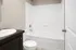 Elegant white bathroom featuring a modern bathtub and sleek vanity, offering a serene and contemporary feel.