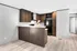Modern kitchen with sleek wooden cabinetry, black appliances, and a spacious breakfast bar in a stylish apartment.