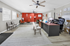 Modern and inviting office space with stylish decor, featuring comfortable seating, vibrant red accent wall, and a sleek executive desk.