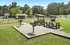 Charming outdoor picnic area with modern grills and shaded seating, set amid lush greenery for a perfect community gathering spot.