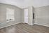Bright and inviting room with sleek wood flooring, neutral walls, and a window allowing natural light to enhance the cozy atmosphere.