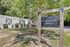 Inviting community office surrounded by lush greenery, offering a welcoming entrance to the mobile home park.