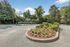 Charming garden area with vibrant flowers and lush greenery surrounded by a paved pathway.