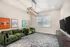 Modern game room with plush green sofas, gaming-themed wall art, stylish chandelier, and dual TVs, perfect for entertainment and relaxation.