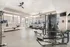 Modern fitness center with state-of-the-art equipment, featuring treadmills, weight machines, and rowers in a spacious, well-lit setting.