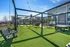Inviting outdoor community space featuring modern swings, lush artificial grass, and ambient string lights under a clear blue sky.