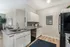 Modern kitchen space with elegant white cabinets, granite countertops, and stainless steel appliances, offering a bright and airy ambiance.