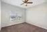 Bright, airy room featuring plush carpet, large windows with blinds, and a modern ceiling fan.