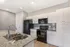 Modern kitchen with elegant granite countertops, sleek stainless-steel sink, and stylish black appliances, exuding contemporary charm.