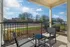 Charming apartment patio featuring cozy seating, perfect for enjoying a sunny day with a picturesque neighborhood view.
