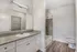 Modern bathroom with elegant granite countertop, sleek cabinetry, and a stylish shower-tub combination, offering a touch of luxury.