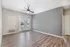 Bright open room with modern wood flooring and sleek gray accent wall, featuring elegant French doors leading to a stunning outdoor view.