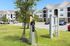 Modern apartment complex with convenient EV charging station in a lush, green setting.