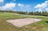 Inviting sand volleyball court set amidst lush green landscaping, perfect for outdoor recreation on sunny days.