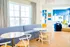 Bright and stylish living area with modern blue furniture, cozy seating, elegant decor, and large windows inviting natural light.