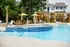 Luxurious outdoor pool area with cascading water features, surrounded by comfortable loungers and vibrant yellow umbrellas, offering a perfect resort-style retreat.