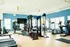 Bright and modern fitness center featuring state-of-the-art exercise equipment, sleek design, and large windows for natural light.