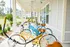Charming apartment community with a covered porch featuring cheerful bicycles, surrounded by lush greenery.