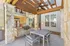 Charming outdoor patio with modern seating and built-in grill under a rustic pergola, perfect for entertaining in a stylish apartment setting.