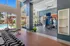 Bright and modern fitness center with high ceilings, featuring state-of-the-art gym equipment, large windows with scenic outdoor views, and direct access to a refreshing pool area.