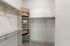 Spacious walk-in closet with organized shelving, ample hanging space, and modern wooden hangers for an elegant storage solution.