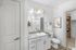 Elegant bathroom with granite countertop, modern lighting, and walk-in closet, featuring stylish decor and ample storage.