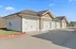 Charming row of modern garages with clean white doors and rustic accents in a well-maintained property.