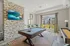Inviting recreation room with elegant stone accent wall, modern decor, and a pool table, ideal for entertainment and relaxation.