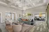 Elegant living room with plush seating, crystal chandeliers, and a cozy office nook, showcasing modern decor and ample natural light.