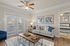 Bright and welcoming living room with elegant decor, featuring cozy sofa, modern artwork, and natural light from large windows.
