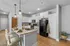 Modern kitchen with elegant marble countertops, sleek black appliances, and stylish pendant lighting, perfect for entertaining.
