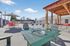 Luxurious outdoor pool area featuring relaxing lounge chairs, a cozy gazebo, and vibrant seating under a clear blue sky.